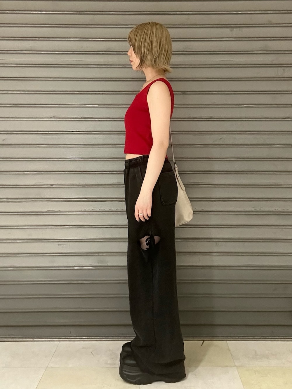 レッド系のTシャツ/カットソー、ブラック系のスウェットパンツ、ブラック系のスニーカーを着用したレディースの夏コーディネートの2枚目の写真