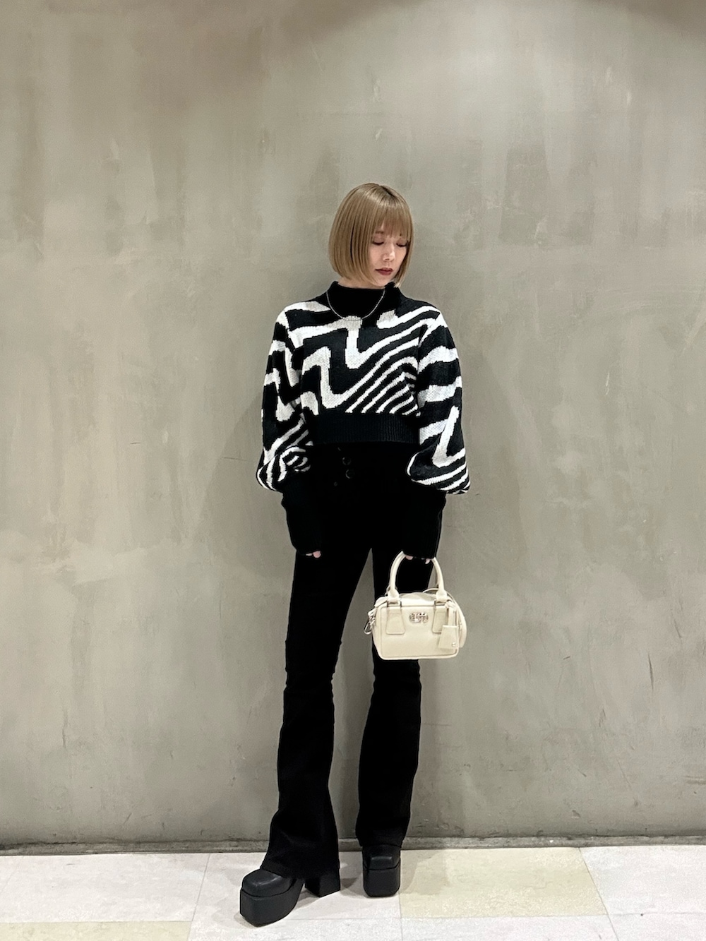 ホワイト系のダウンジャケット/コート、ブラック系のニット/セーター、ブラック系のデニムパンツを着用したレディースの冬コーディネートの2枚目の写真