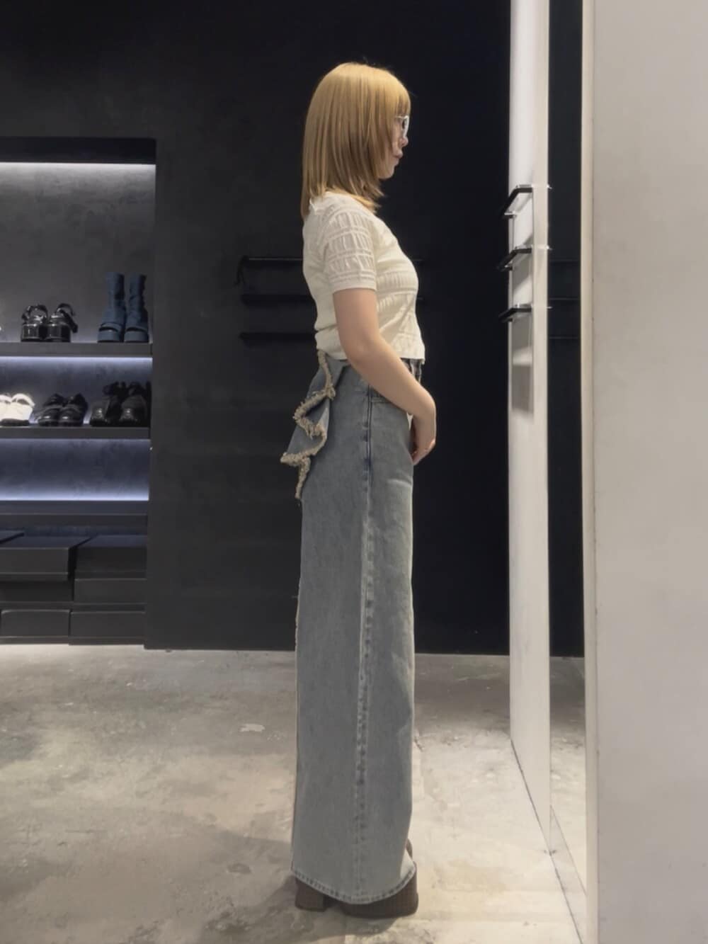 ホワイト系のニット/セーター、ブルー系のデニムパンツ、ベージュ系のサンダルを着用したレディースの夏コーディネートの2枚目の写真