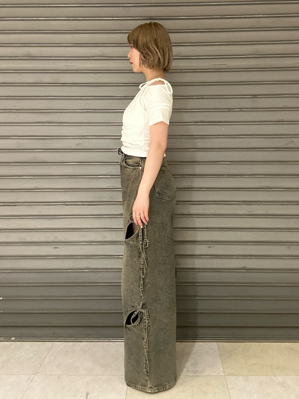 ブラック系のショルダーバッグ、ホワイト系のTシャツ/カットソー、ブルー系のデニムパンツを着用したレディースの春コーディネートの2枚目の写真