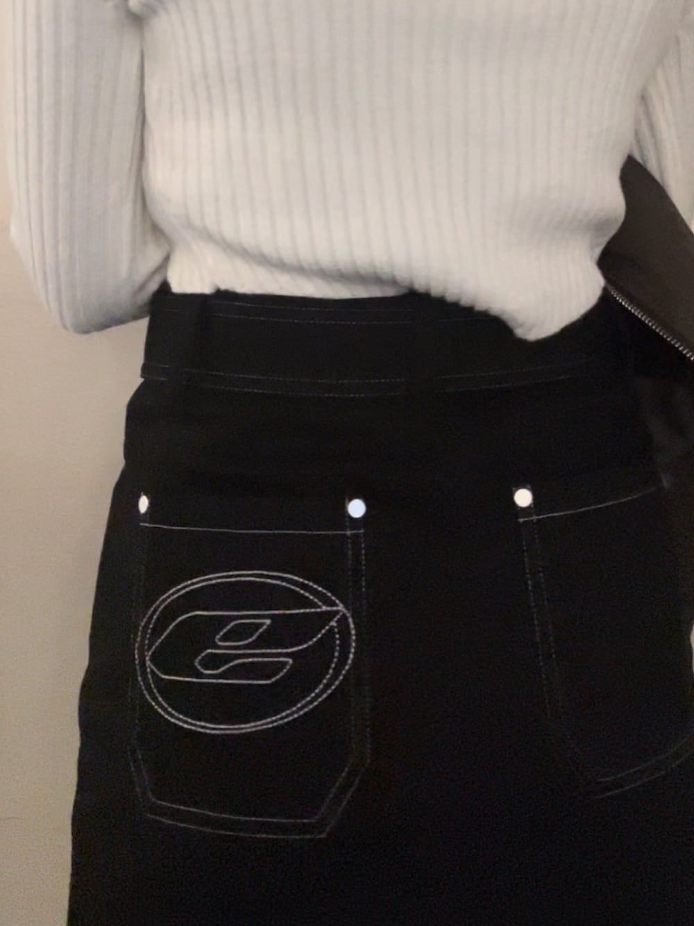 ホワイト系のニット/セーター、ブラウン系のブルゾン、ブラック系のスカートを着用したレディースの冬コーディネートの9枚目の写真