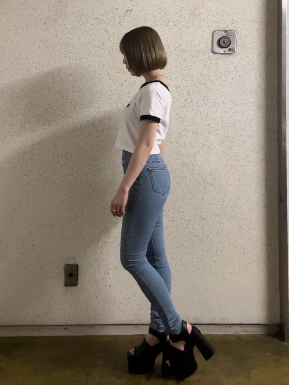 ホワイト系のTシャツ/カットソー、ブルー系のデニムパンツ、ブラック系のサンダルを着用したレディースの春コーディネートの2枚目の写真