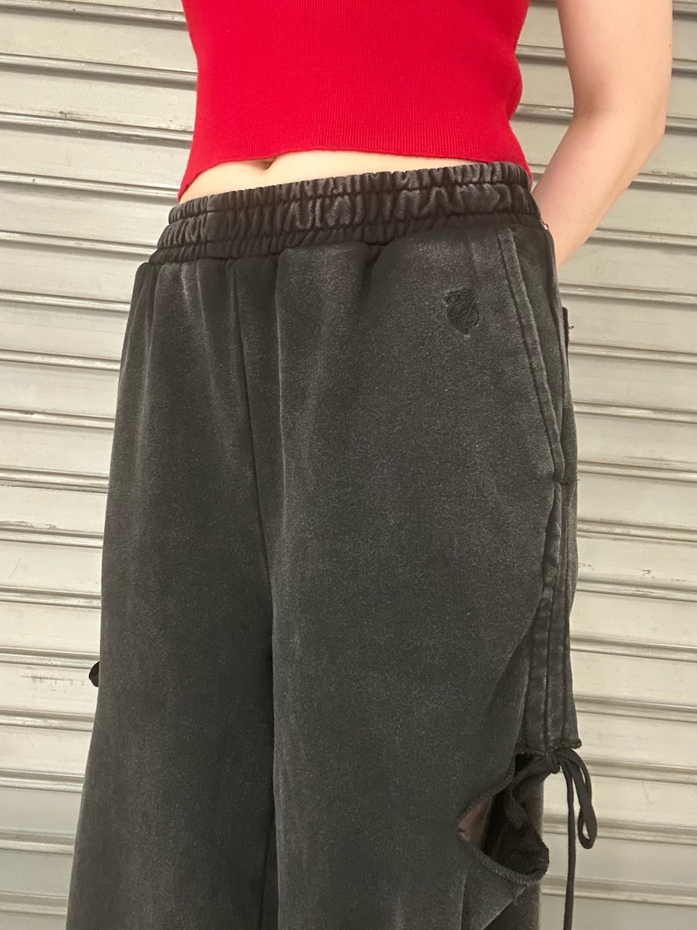 レッド系のTシャツ/カットソー、ブラック系のスウェットパンツ、ブラック系のスニーカーを着用したレディースの夏コーディネートの5枚目の写真