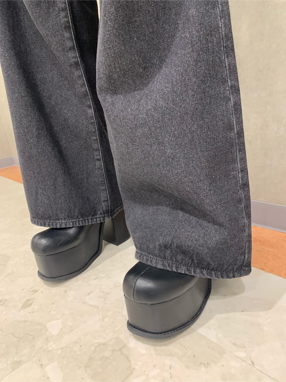 ブラック系のブーツ、ブラック系のデニムパンツ、ホワイト系のTシャツ/カットソーを着用したレディースの秋コーディネートの6枚目の写真