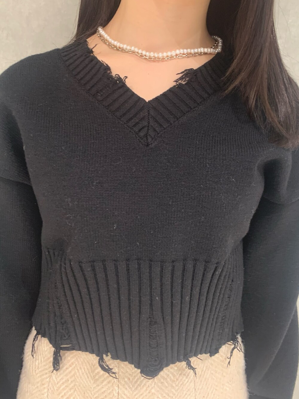 ブラック系のニット/セーター、ベージュ系のスカート、ブラック系のハンドバッグを着用したレディースの冬コーディネートの3枚目の写真