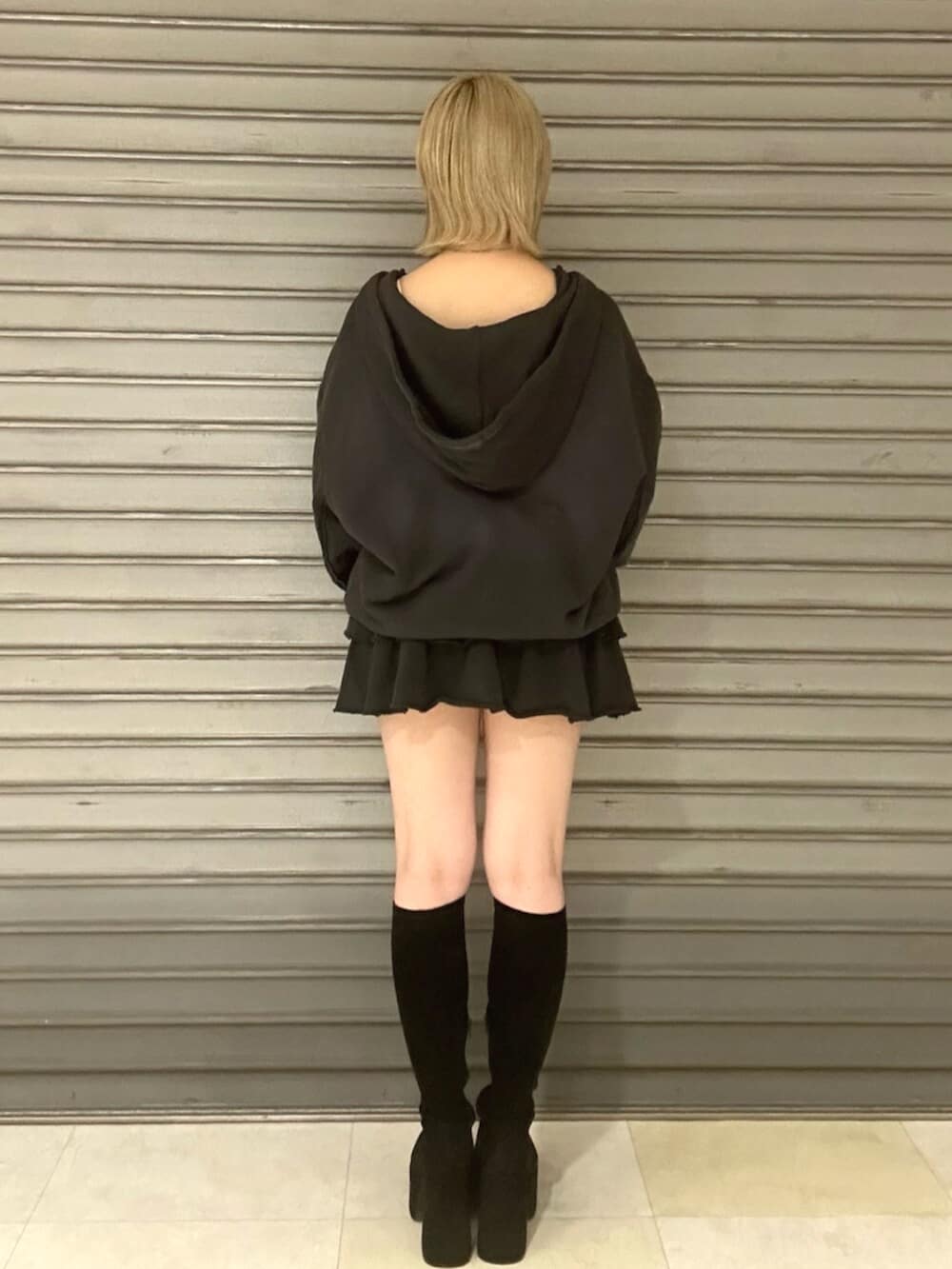 ブラック系のブーツ、グレー系のパーカー、グレー系のスカートを着用したレディースの秋コーディネートの3枚目の写真