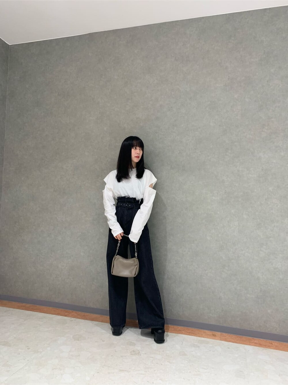 ブラック系のブーツ、ブラック系のデニムパンツ、ホワイト系のTシャツ/カットソーを着用したレディースの秋コーディネートの2枚目の写真