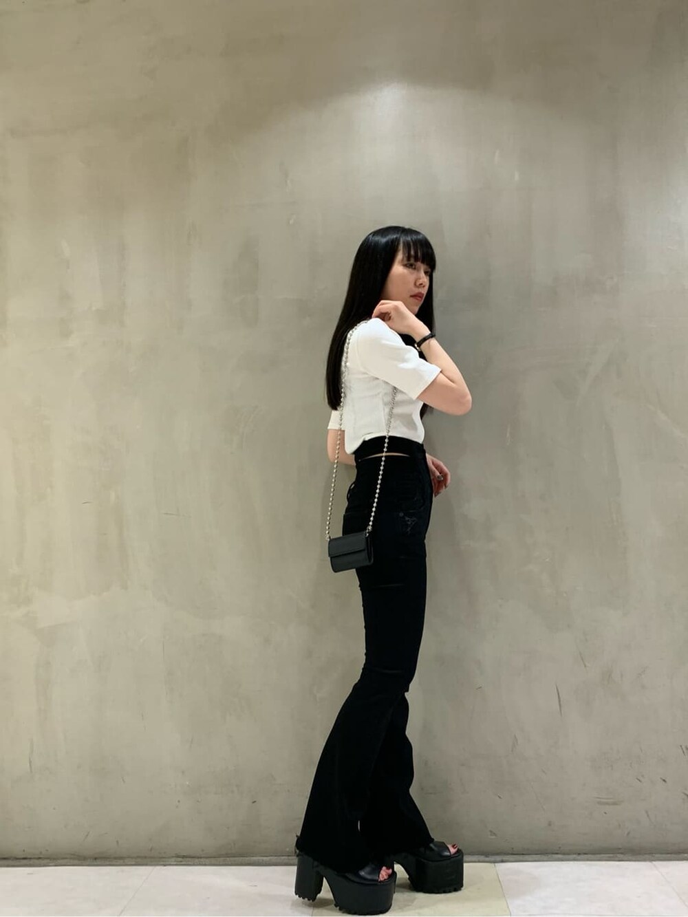 ブラック系のサンダル、ブラック系のデニムパンツ、ホワイト系のTシャツ/カットソーを着用したレディースの夏コーディネートの2枚目の写真