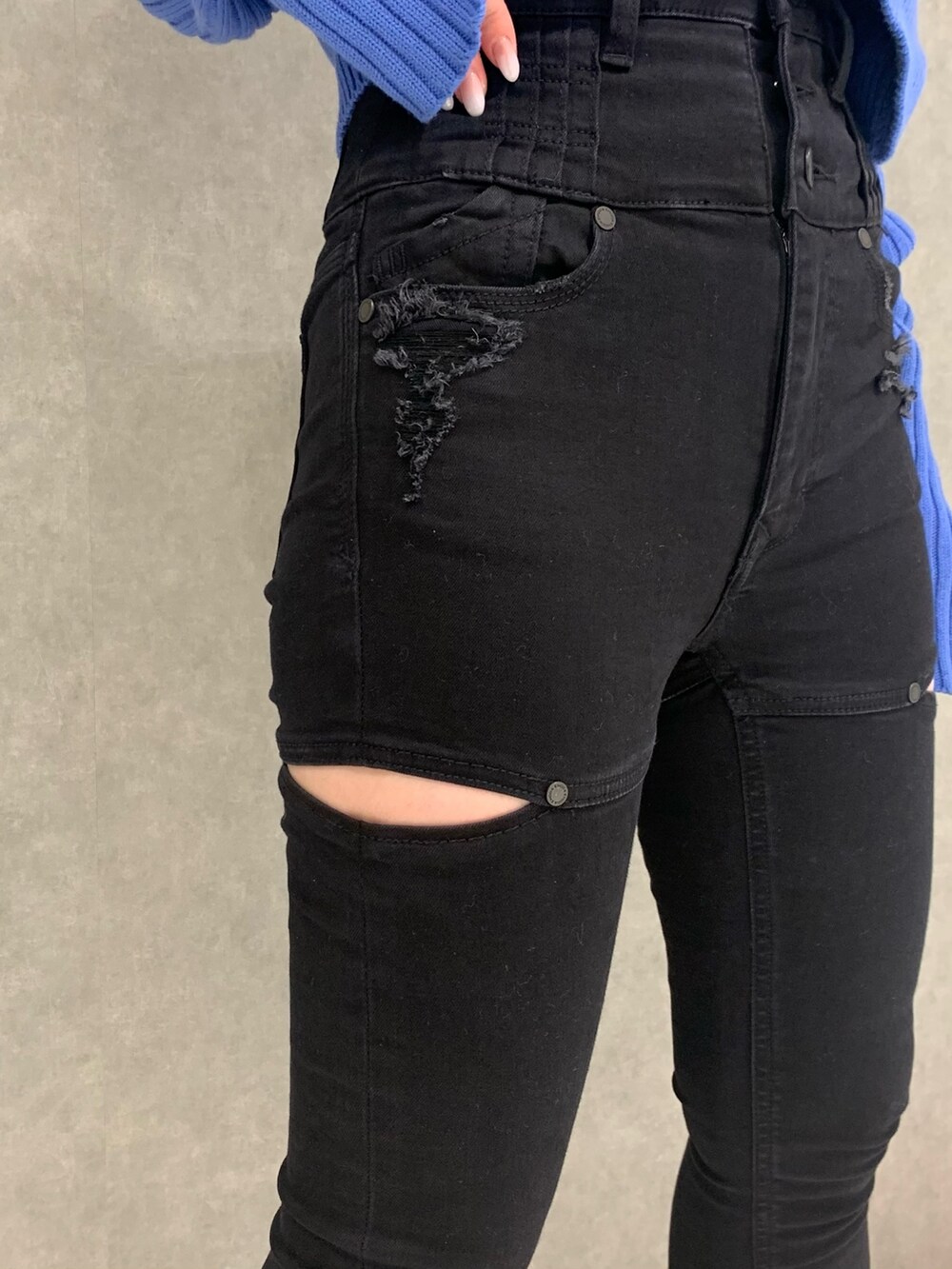 ブラック系のデニムパンツ、ブルー系のカーディガン/ボレロ、ブラック系のブーツを着用したレディースの冬コーディネートの4枚目の写真