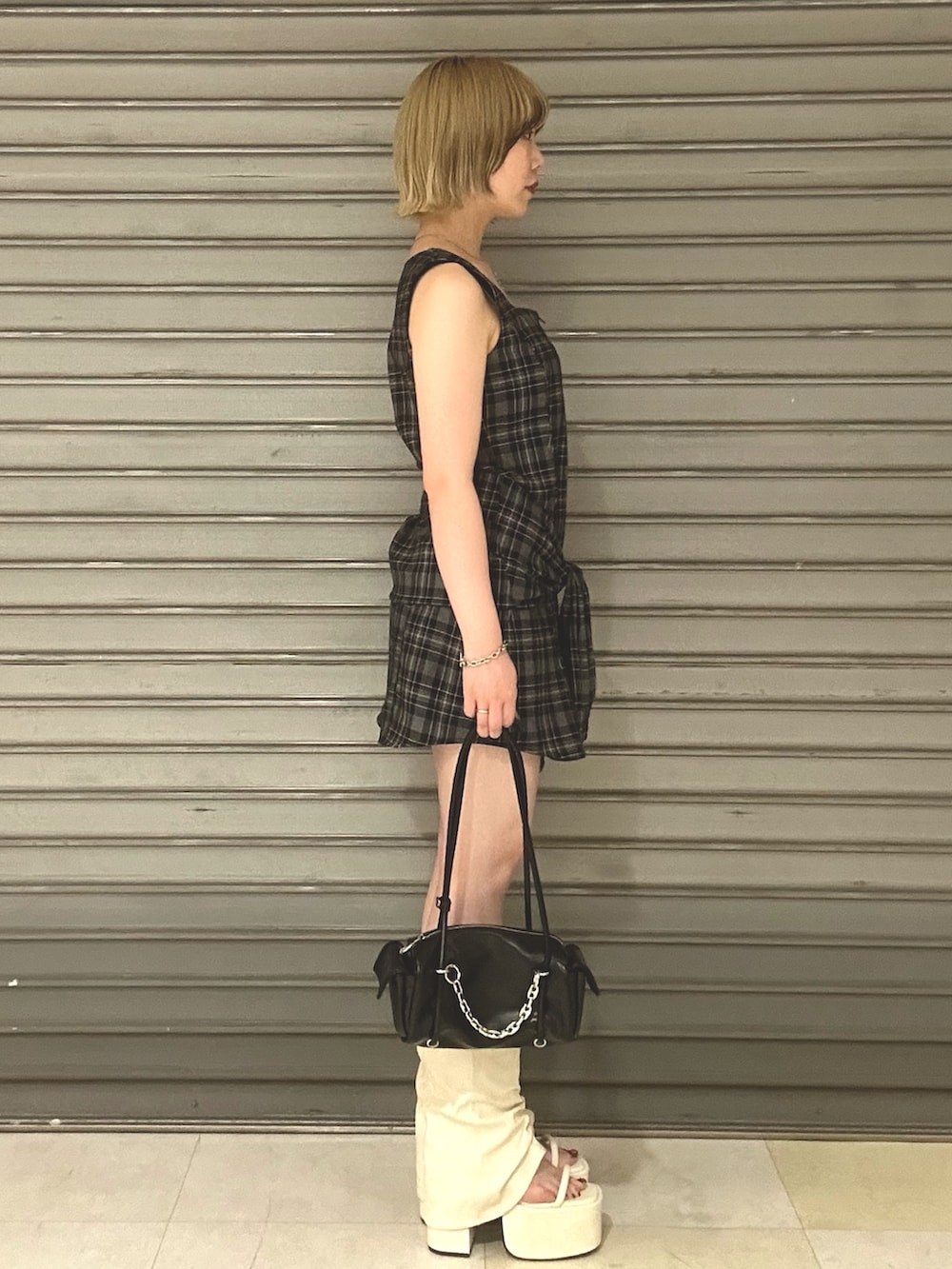 ホワイト系のサンダル、ブラック系のハンドバッグ、グレー系のワンピースを着用したレディースの夏コーディネートの2枚目の写真