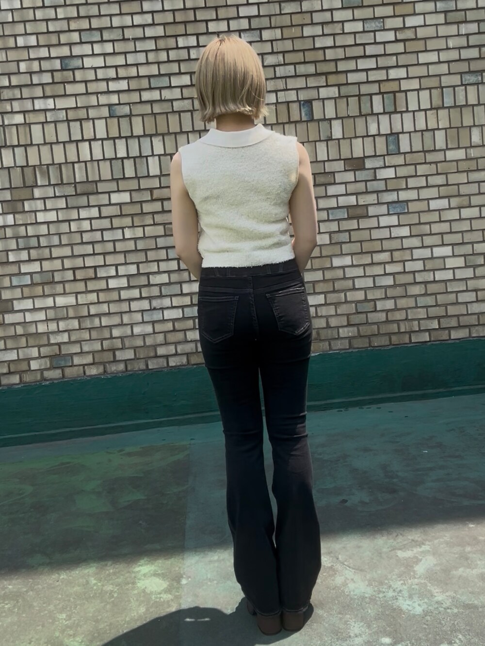 ホワイト系のニット/セーター、ブラウン系のサンダル、ブラック系のサングラスを着用したレディースの夏コーディネートの3枚目の写真