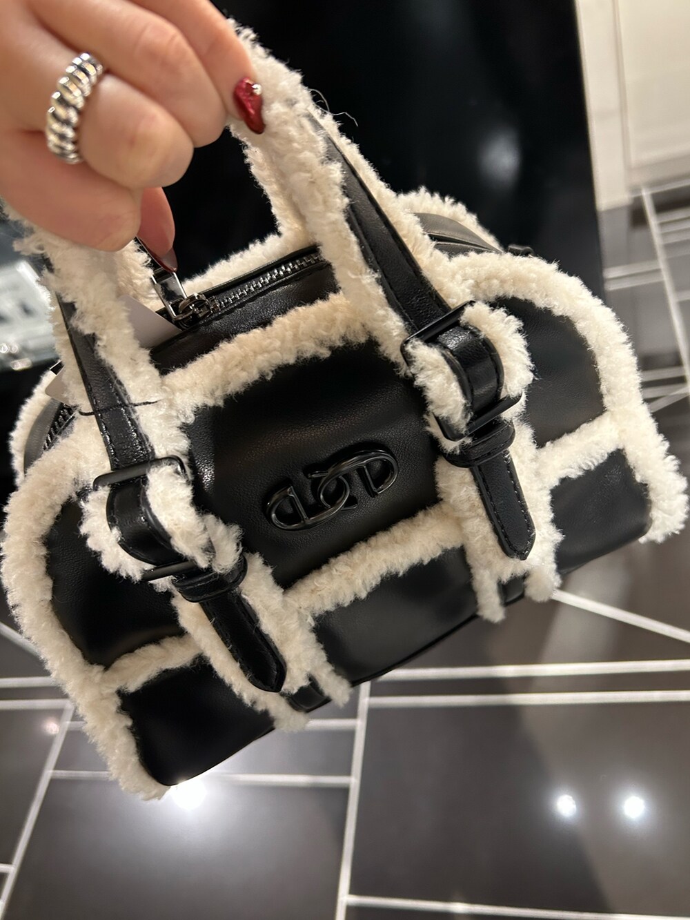 ブラック系のニット/セーター、ブラック系のブーツ、ブラック系のデニムパンツを着用したレディースの秋コーディネートの5枚目の写真