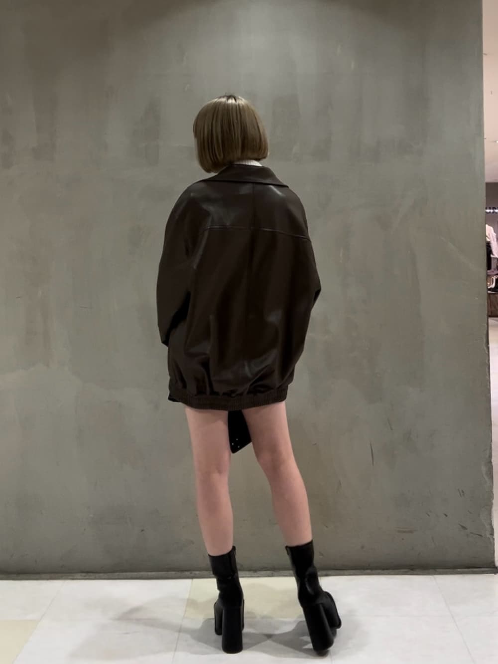 ホワイト系のニット/セーター、ブラウン系のブルゾン、ブラック系のスカートを着用したレディースの冬コーディネートの5枚目の写真