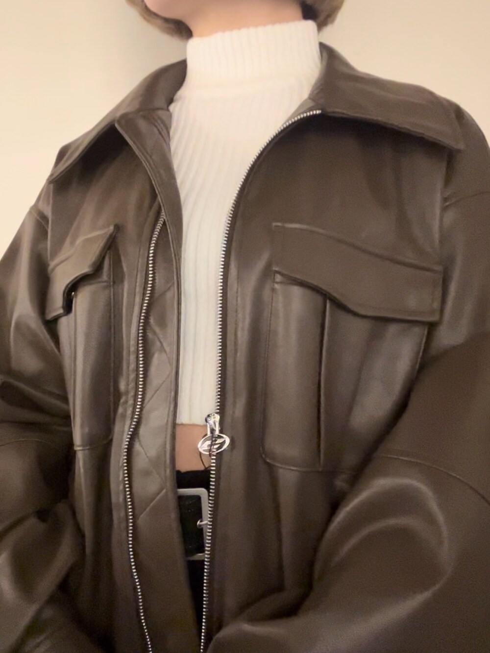 ホワイト系のニット/セーター、ブラウン系のブルゾン、ブラック系のスカートを着用したレディースの冬コーディネートの7枚目の写真