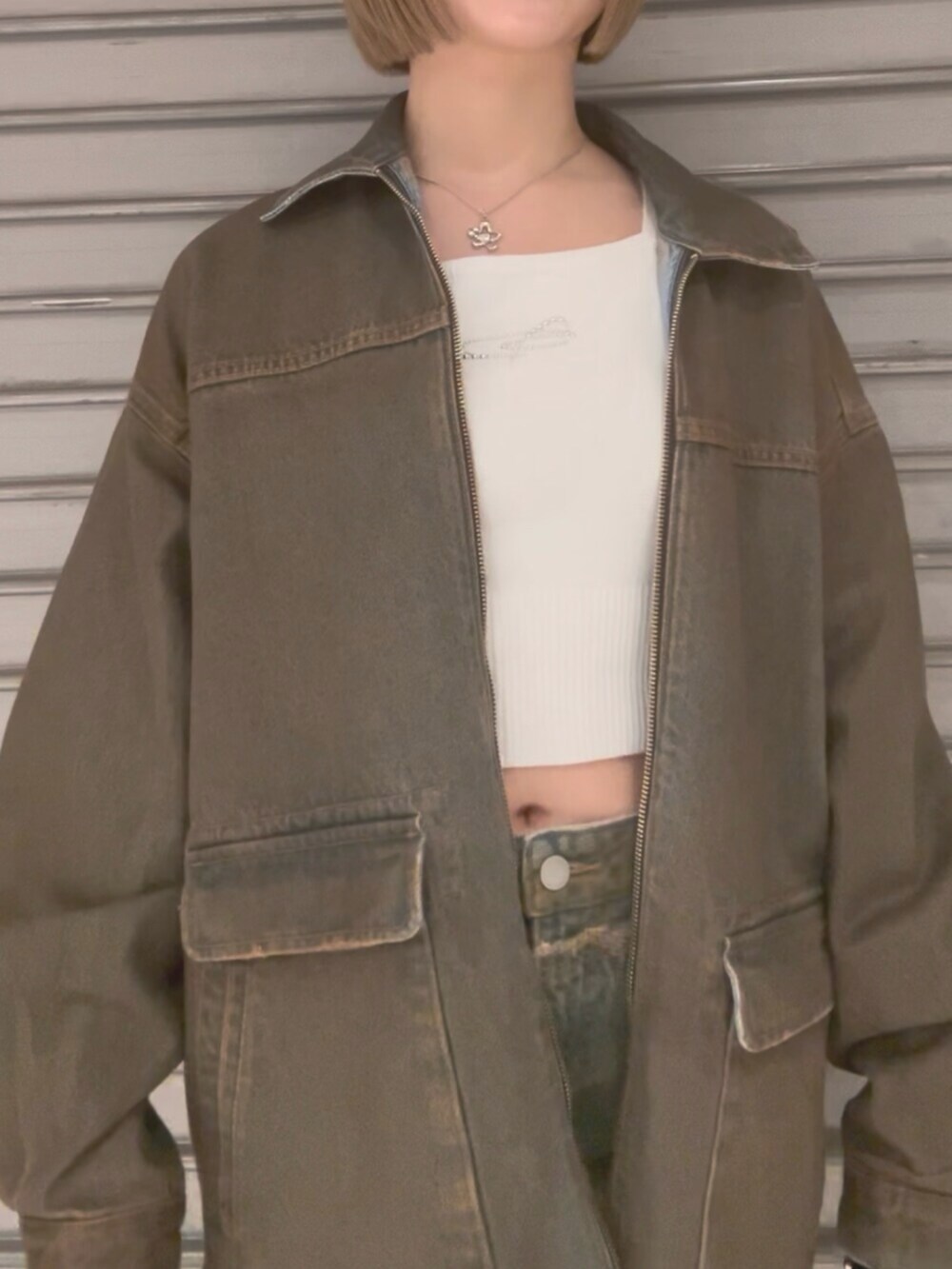 ブラウン系のブルゾン、ホワイト系のニット/セーター、ブラウン系のスカートを着用したレディースの冬コーディネートの7枚目の写真