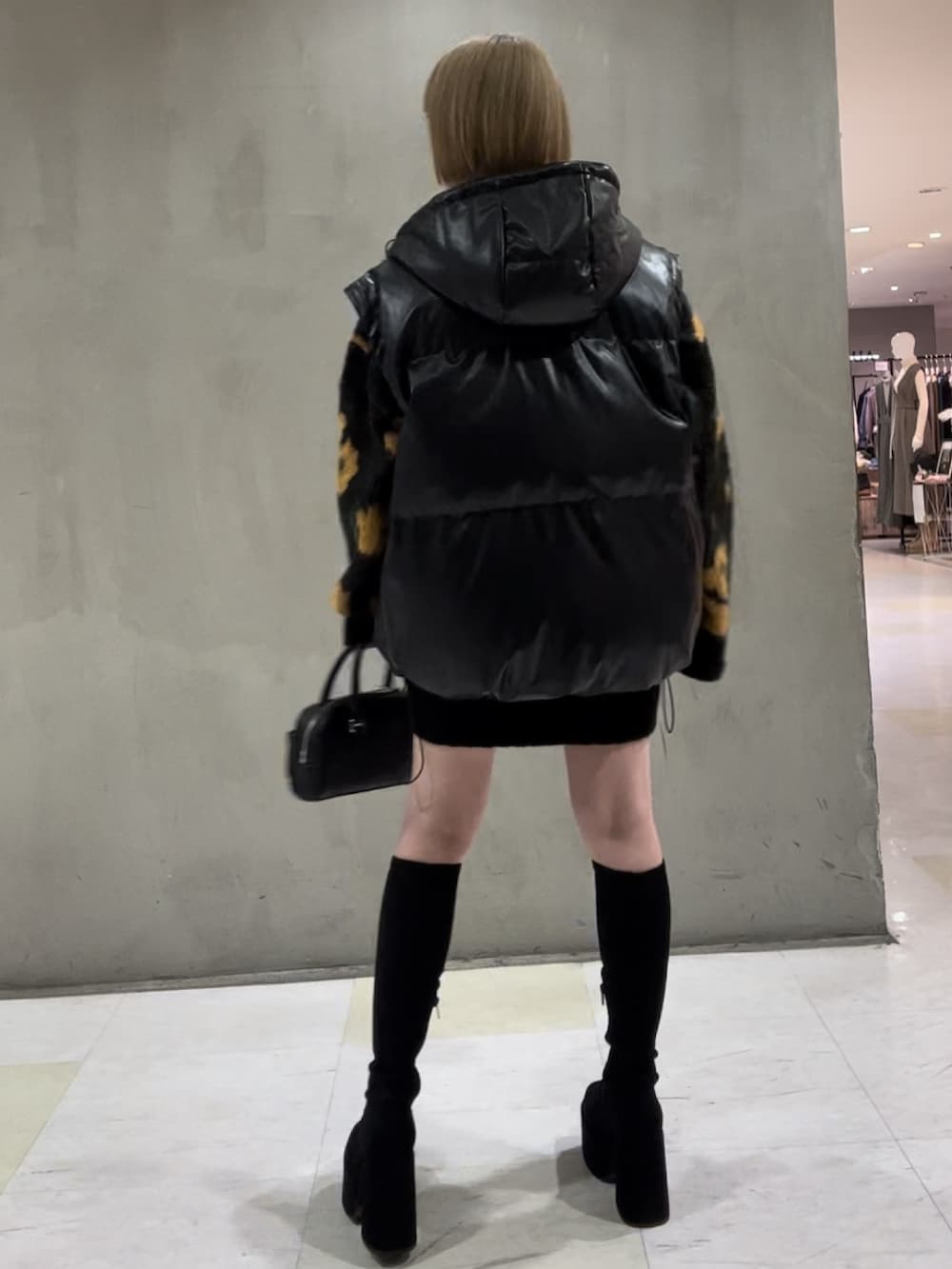 その他のブルゾン、オレンジ系のニット/セーター、ブラック系のハンドバッグを着用したレディースの秋コーディネートの5枚目の写真