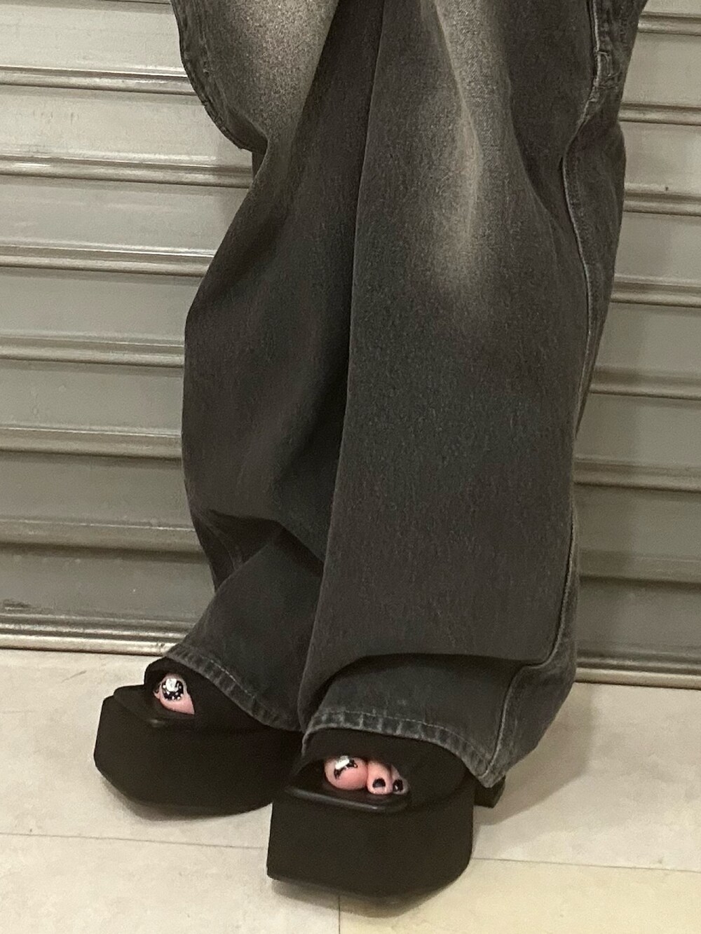 グリーン系のTシャツ/カットソー、ブラック系のデニムパンツ、ブラウン系のハンドバッグを着用したレディースの夏コーディネートの6枚目の写真