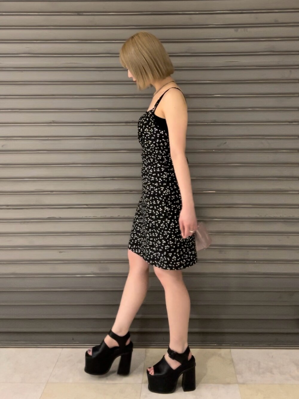 ブラック系のハンドバッグ、ブラック系のサンダル、その他のワンピースを着用したレディースの夏コーディネートの2枚目の写真