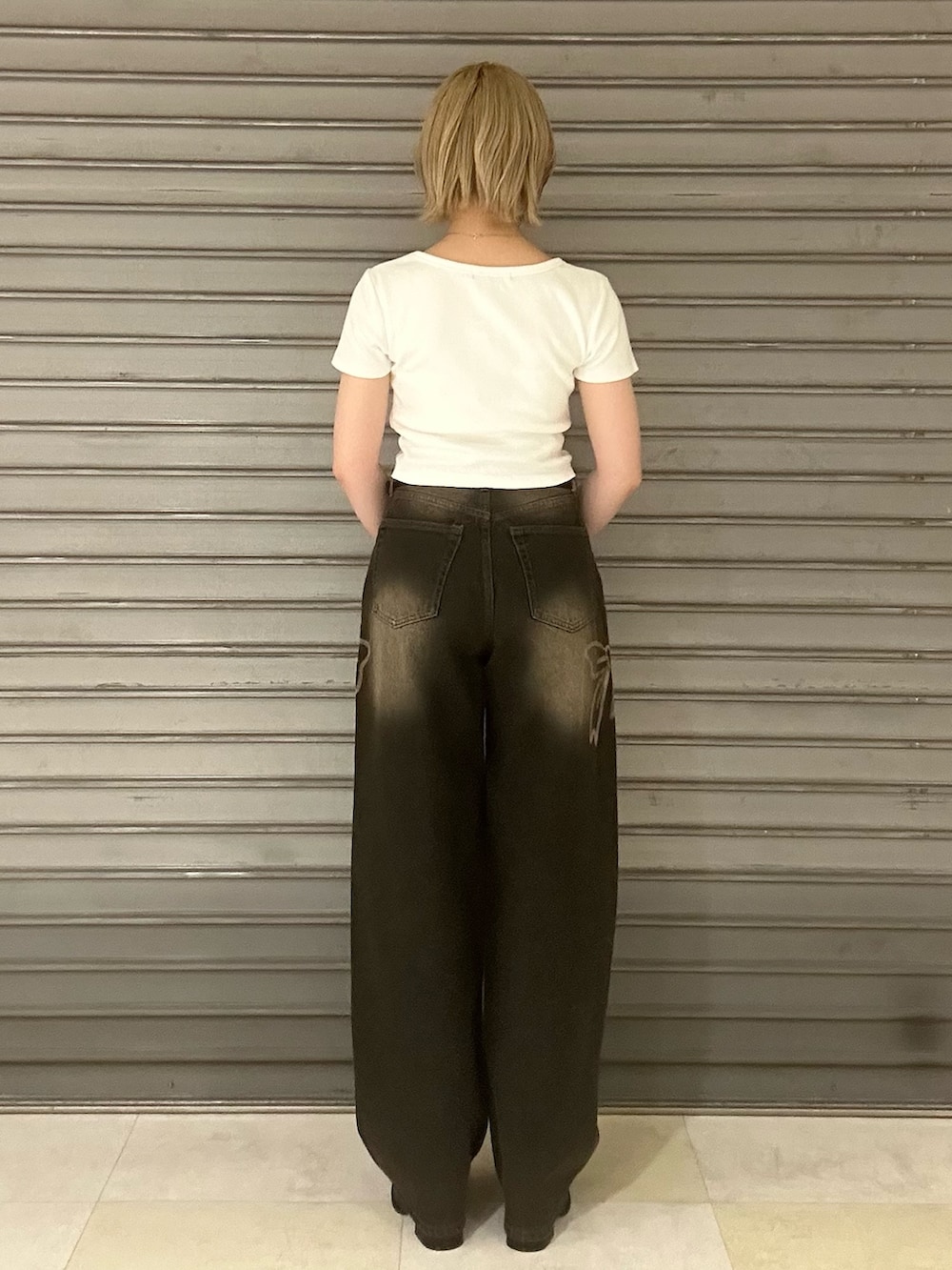 ホワイト系のTシャツ/カットソー、ブラック系のデニムパンツ、ブラック系のサンダルを着用したレディースの夏コーディネートの4枚目の写真