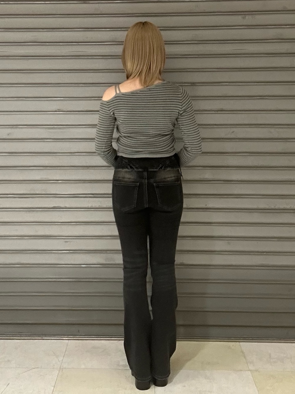 ブラック系のブーツ、グレー系のニット/セーター、ブラック系のデニムパンツを着用したレディースの冬コーディネートの3枚目の写真