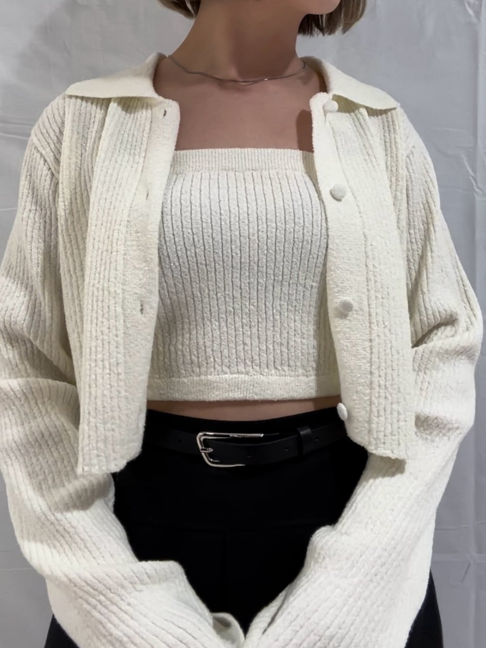 ホワイト系のニット/セーター、ブラック系のスカート、ブラック系のサンダルを着用したレディースの春コーディネートの4枚目の写真