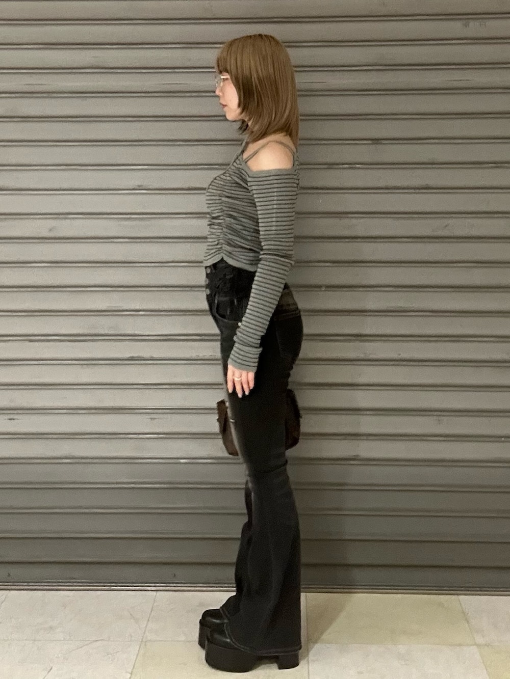 ブラック系のブーツ、グレー系のニット/セーター、ブラック系のデニムパンツを着用したレディースの冬コーディネートの2枚目の写真