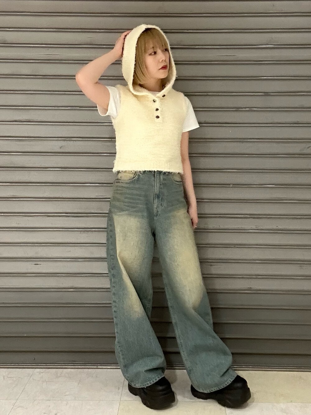 ホワイト系のニット/セーター、ホワイト系のTシャツ/カットソー、ブルー系のデニムパンツを着用したレディースの春コーディネートの4枚目の写真