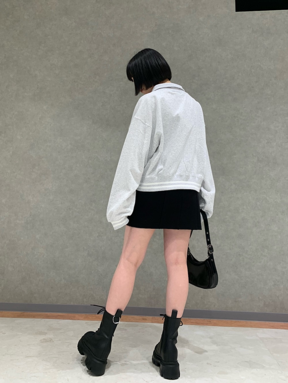 グレー系のTシャツ/カットソー、ブラック系のスカート、ブラック系のハンドバッグを着用したレディースの春コーディネートの3枚目の写真