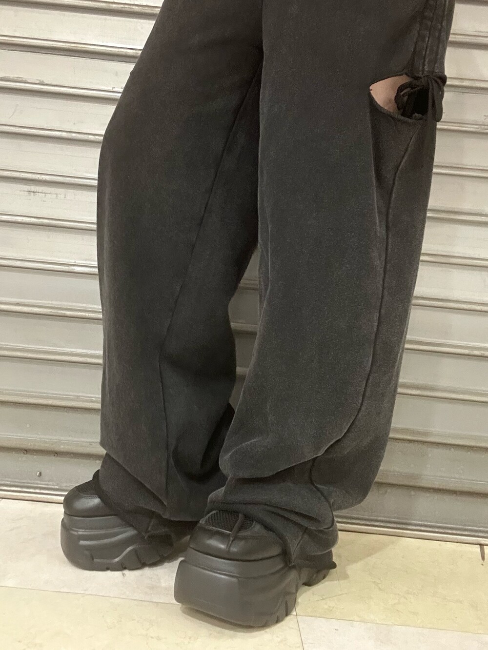 レッド系のTシャツ/カットソー、ブラック系のスウェットパンツ、ブラック系のスニーカーを着用したレディースの夏コーディネートの6枚目の写真