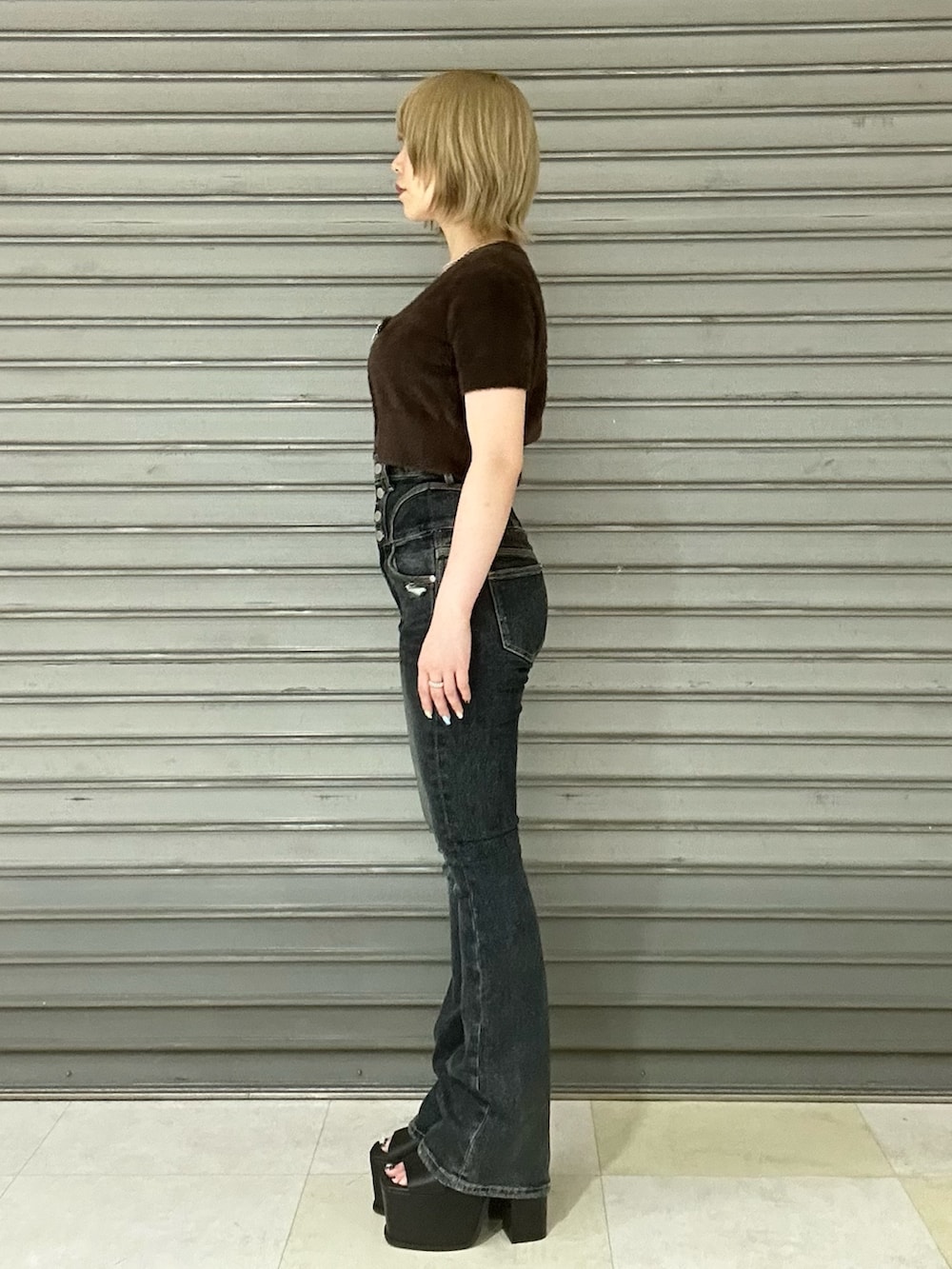 ブラック系のサンダル、ブルー系のデニムパンツ、ブラウン系のニット/セーターを着用したレディースの夏コーディネートの2枚目の写真