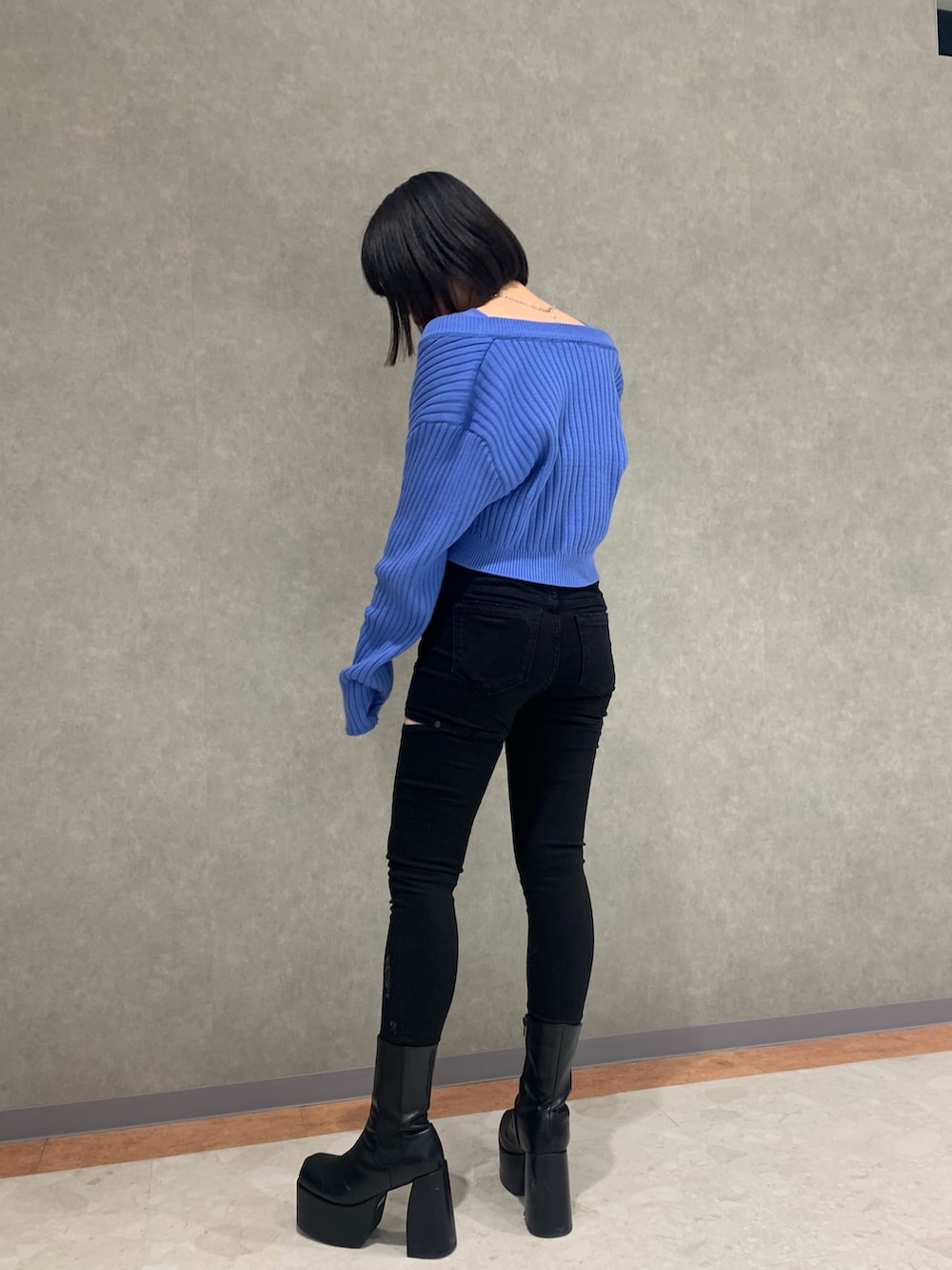 ブラック系のデニムパンツ、ブルー系のカーディガン/ボレロ、ブラック系のブーツを着用したレディースの冬コーディネートの2枚目の写真