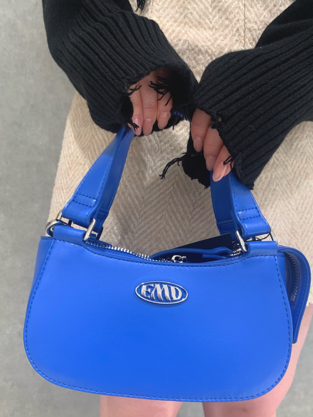 ブラック系のニット/セーター、ベージュ系のスカート、ブラック系のハンドバッグを着用したレディースの冬コーディネートの5枚目の写真