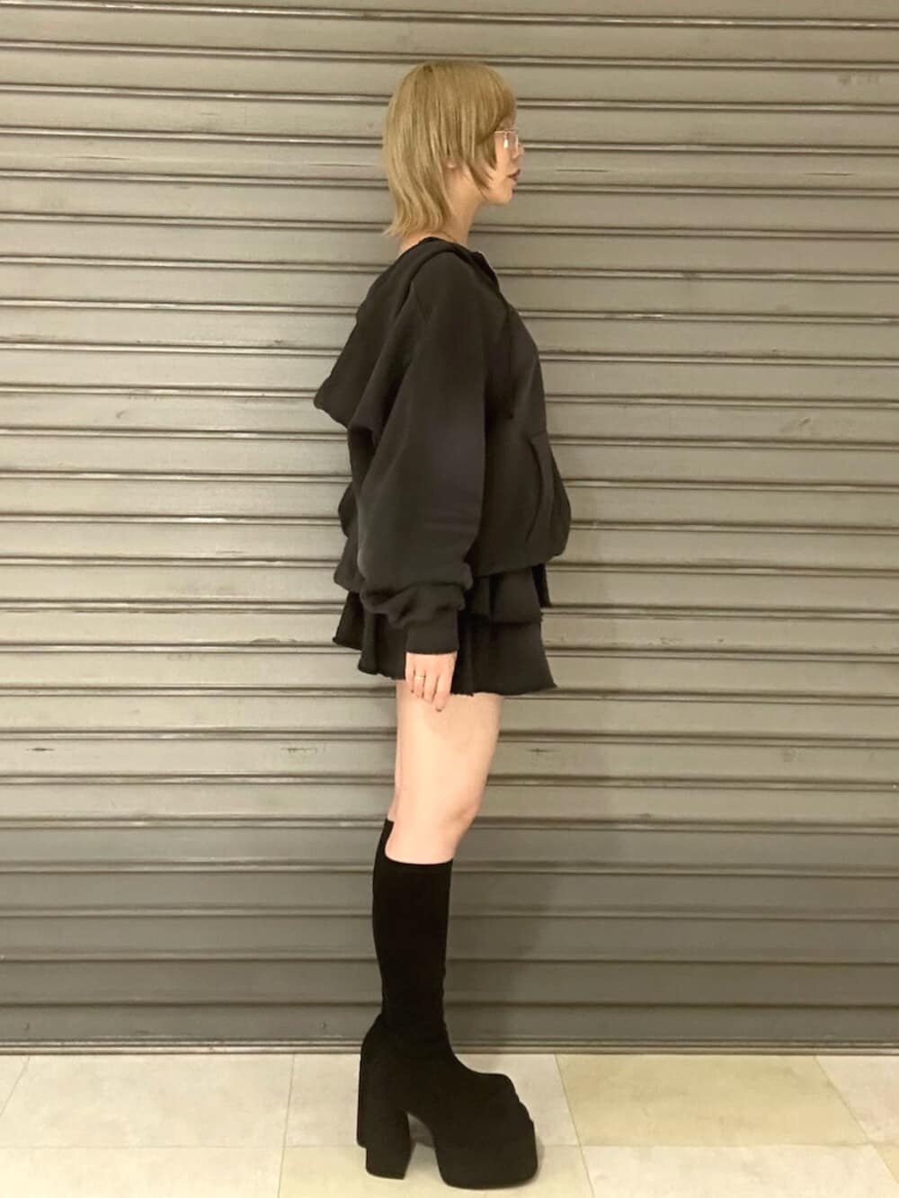 ブラック系のブーツ、グレー系のパーカー、グレー系のスカートを着用したレディースの秋コーディネートの2枚目の写真