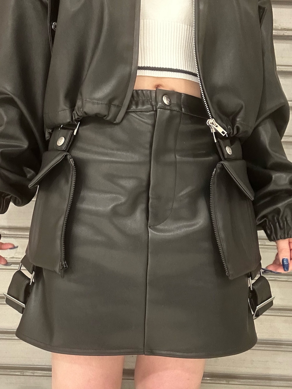 ブラック系のブルゾン、ホワイト系のニット/セーター、ブラック系のスカートを着用したレディースの冬コーディネートの5枚目の写真