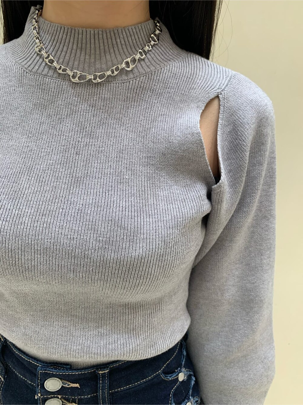 ブラック系のハンドバッグ、ブルー系のデニムパンツ、グレー系のニット/セーターを着用したレディースの秋コーディネートの4枚目の写真