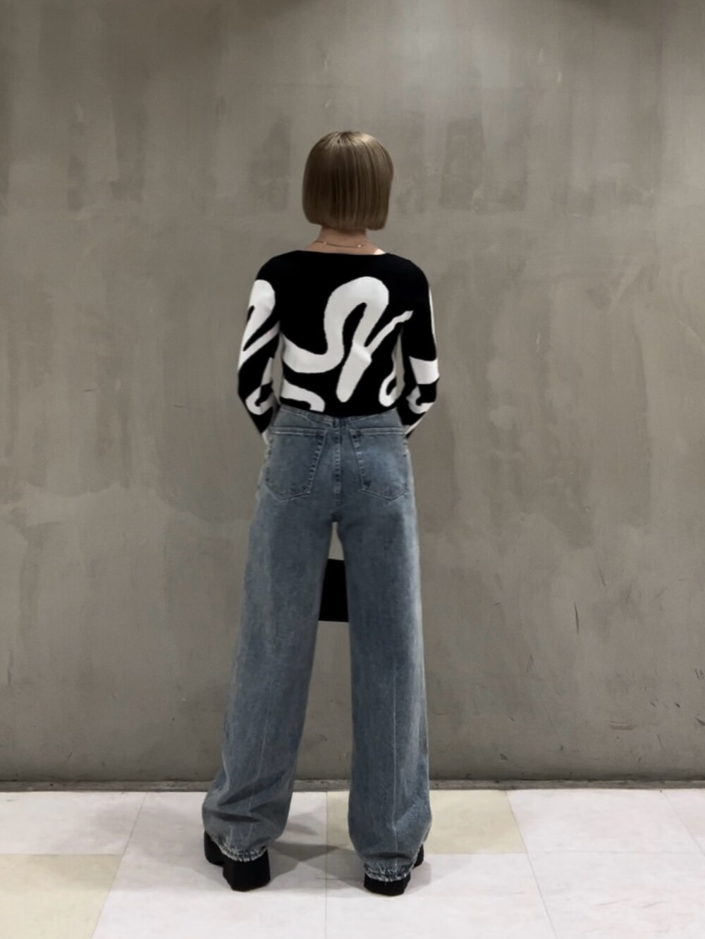 その他のニット/セーター、ホワイト系のキャミソール、ブラック系のショルダーバッグを着用したレディースの冬コーディネートの3枚目の写真