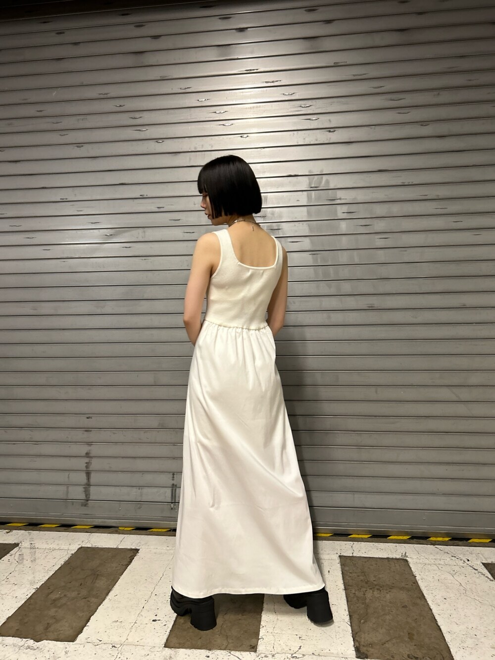 ホワイト系のワンピース、ブラック系のハンドバッグ、ブラック系のサンダルを着用したレディースの夏コーディネートの3枚目の写真