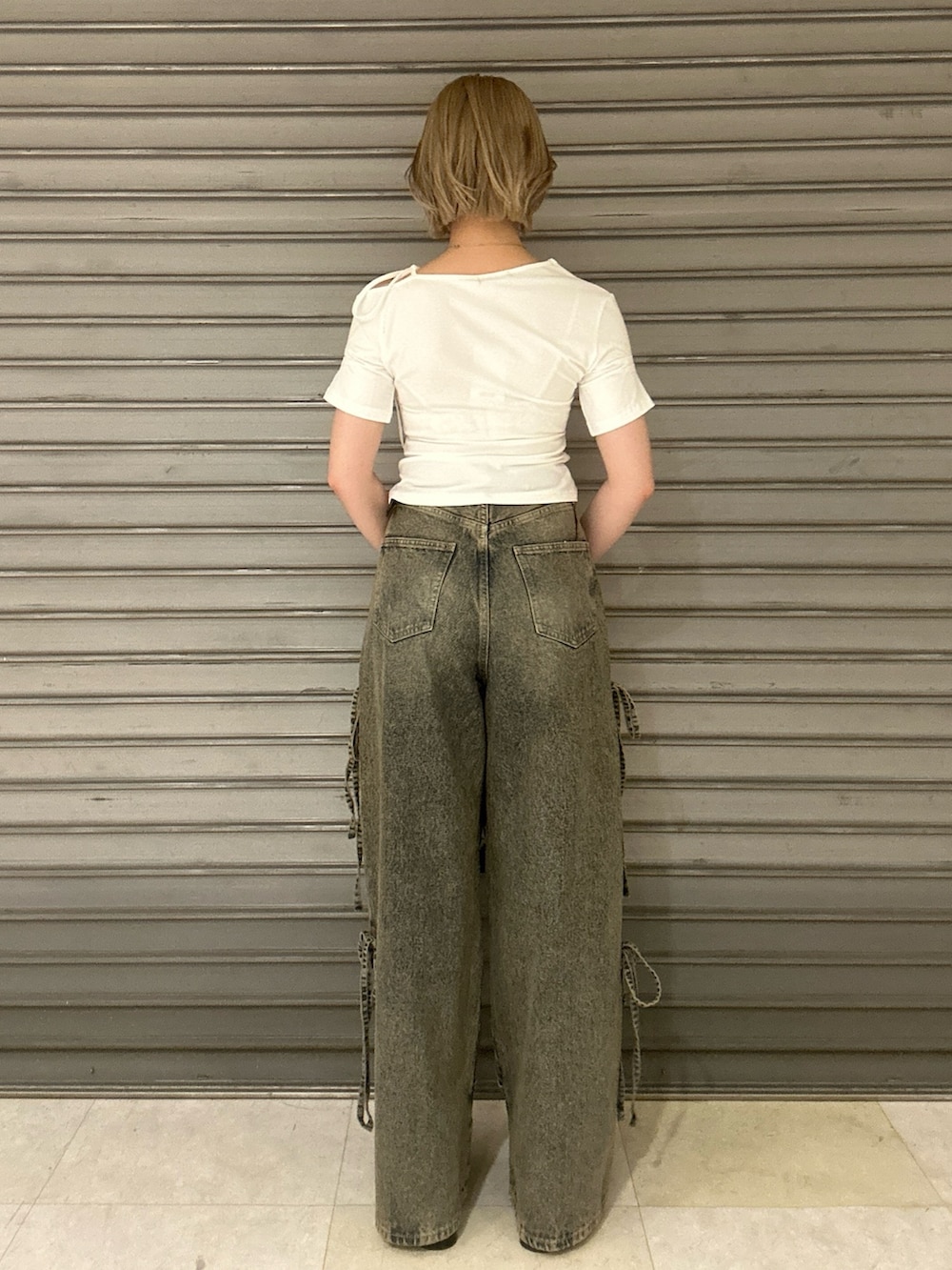 ブラック系のショルダーバッグ、ホワイト系のTシャツ/カットソー、ブルー系のデニムパンツを着用したレディースの春コーディネートの3枚目の写真