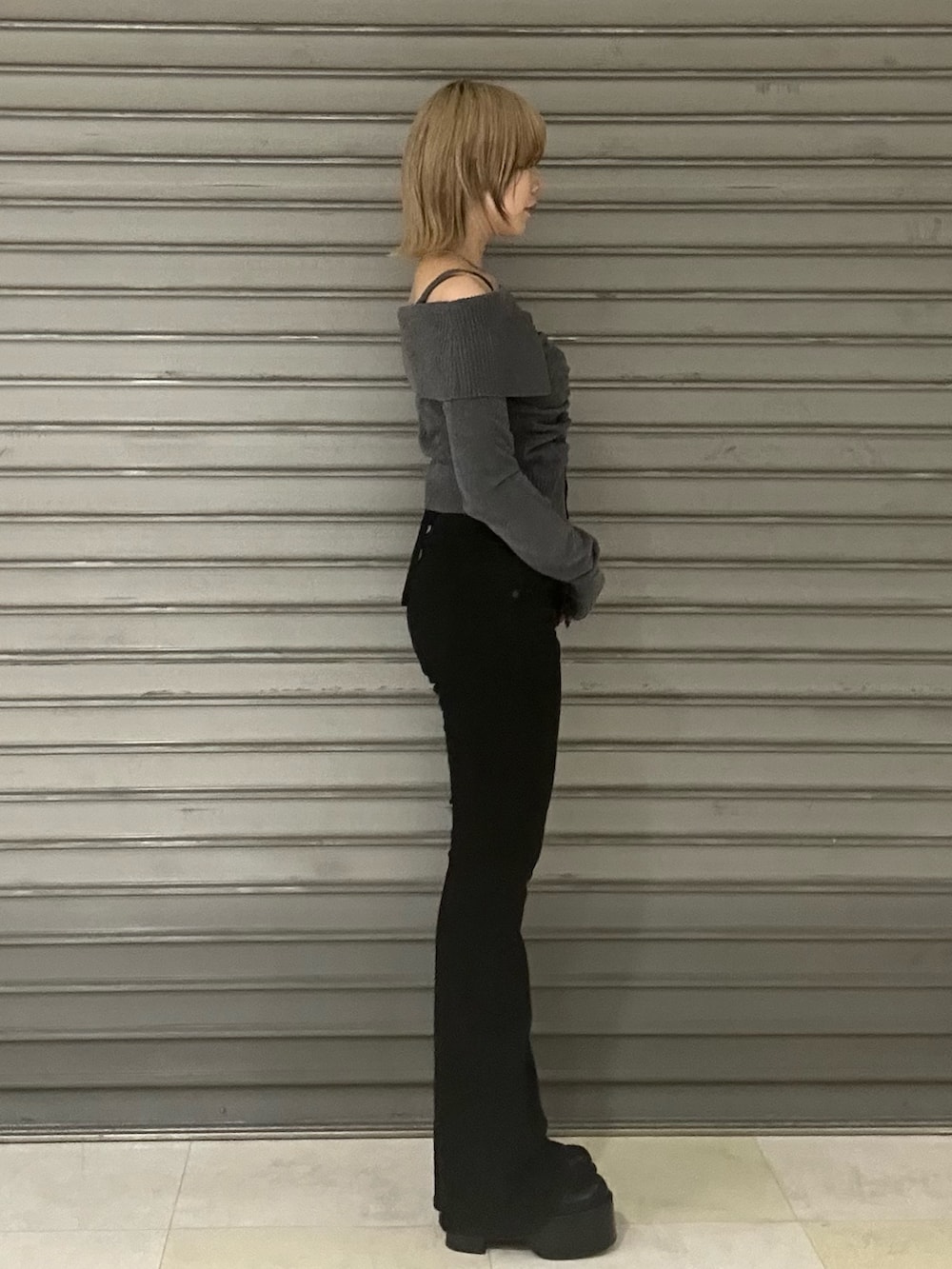 ブラック系のブーツ、グレー系のニット/セーター、ブラック系のデニムパンツを着用したレディースの秋コーディネートの2枚目の写真