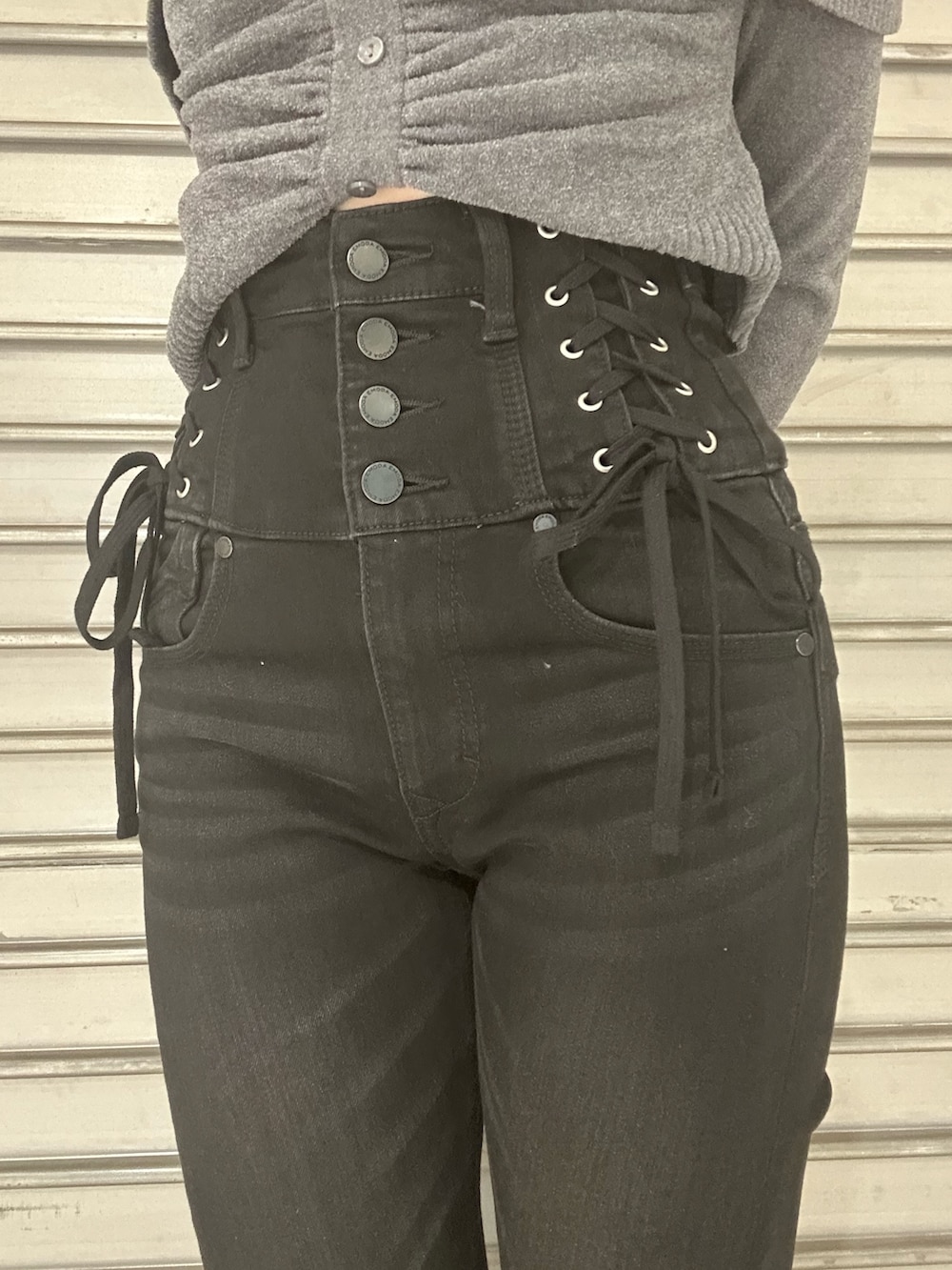 ブラック系のブーツ、グレー系のニット/セーター、ブラック系のデニムパンツを着用したレディースの秋コーディネートの5枚目の写真