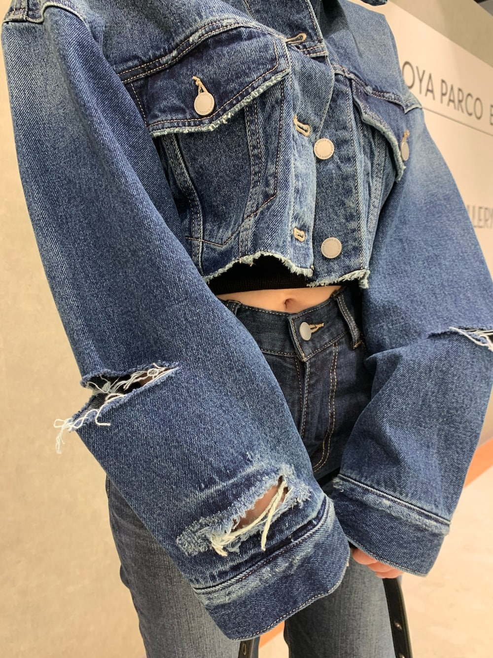 ブルー系のデニムパンツ、ブルー系のデニムジャケット、ブラック系のキャミソールを着用したレディースの春コーディネートの4枚目の写真