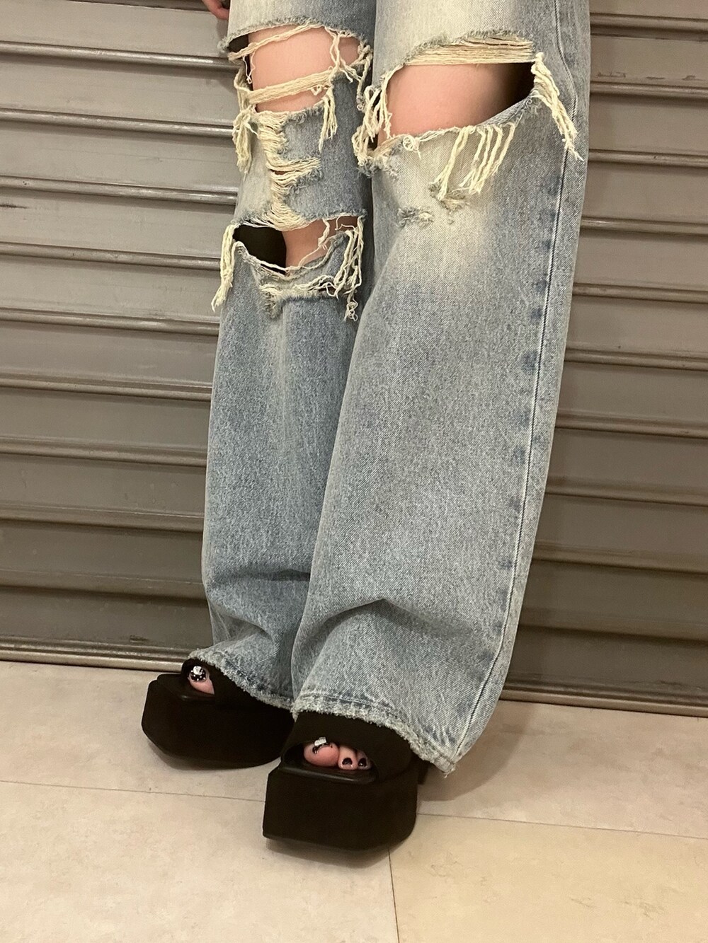 ブラウン系のタンクトップ、ブルー系のデニムパンツ、ブラック系のサンダルを着用したレディースの夏コーディネートの6枚目の写真