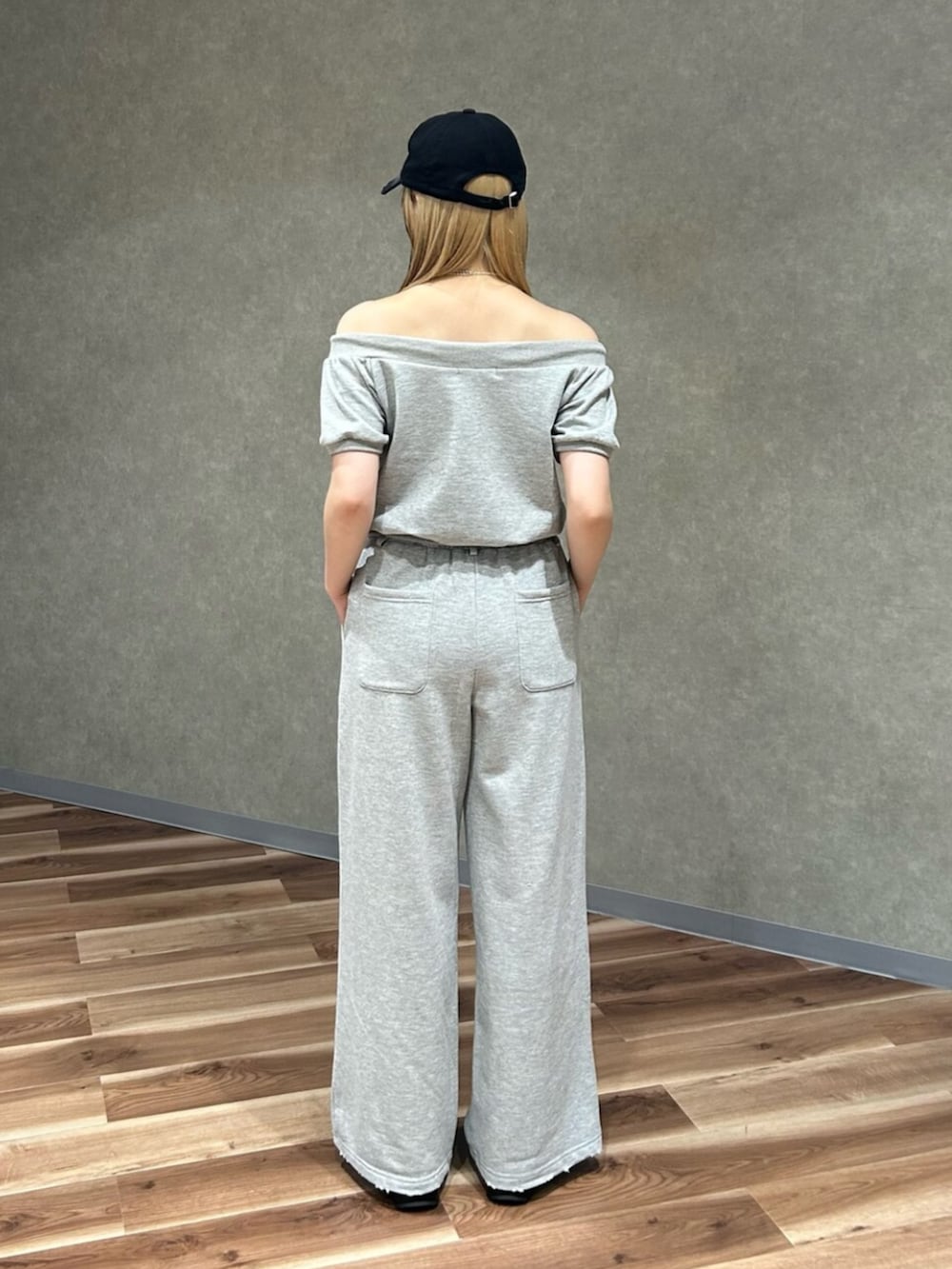 グレー系のスウェット、グレー系のスウェットパンツ、ブラック系のサンダルを着用したレディースの夏コーディネートの3枚目の写真