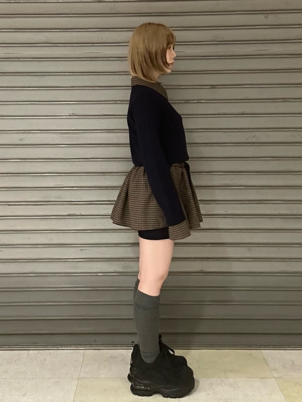 ブラック系のスニーカー、ブルー系のシャツ/ブラウス、ブルー系のスカートを着用したレディースの冬コーディネートの2枚目の写真