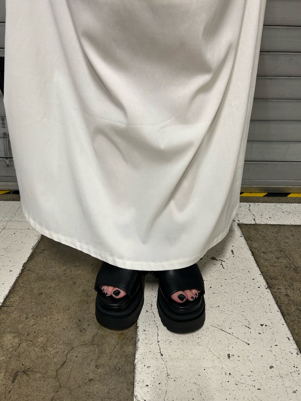 ホワイト系のワンピース、ブラック系のハンドバッグ、ブラック系のサンダルを着用したレディースの夏コーディネートの6枚目の写真