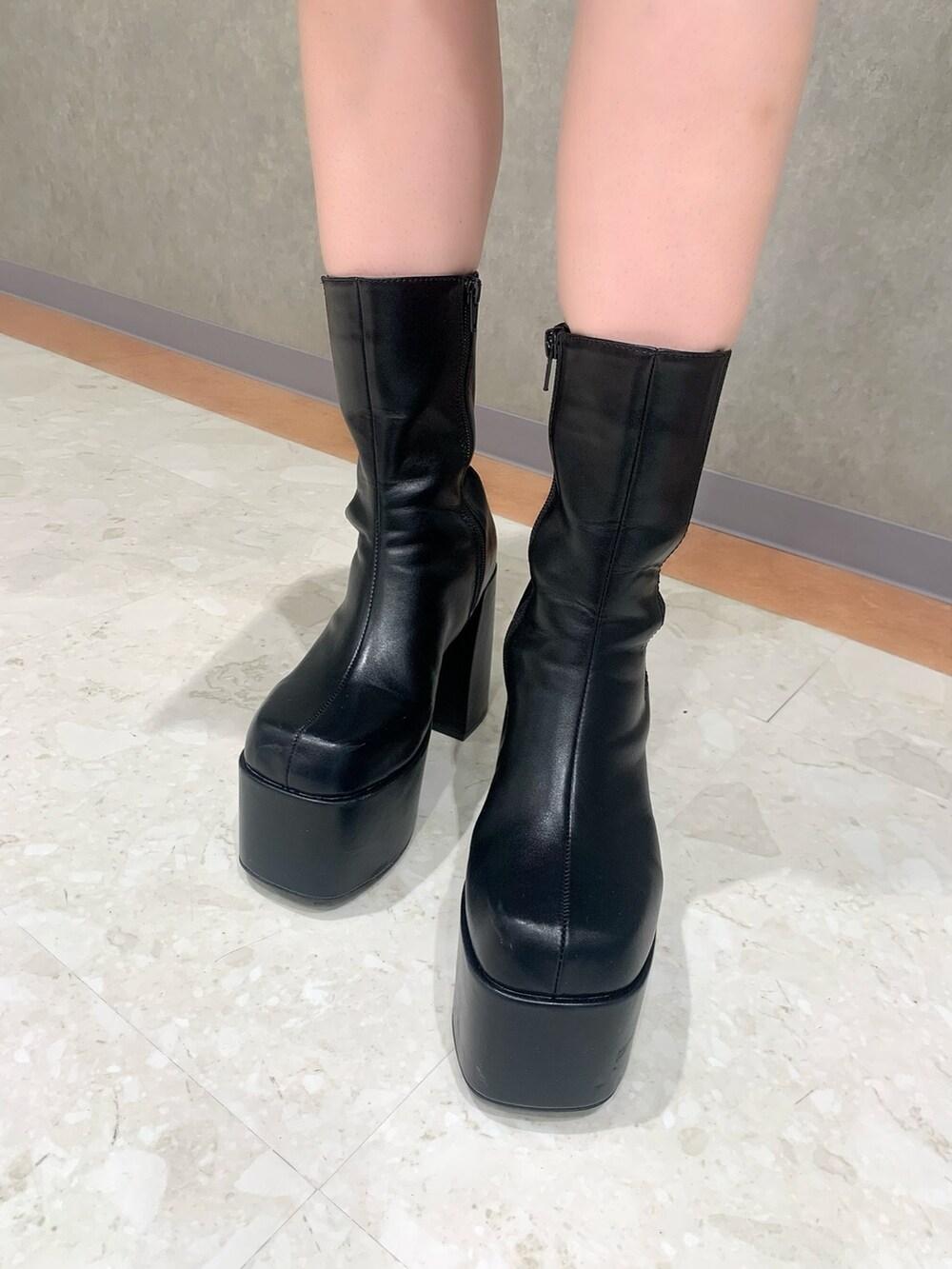 グレー系のワンピース、ブラック系のハンドバッグ、ブラック系のブーツを着用したレディースの冬コーディネートの5枚目の写真