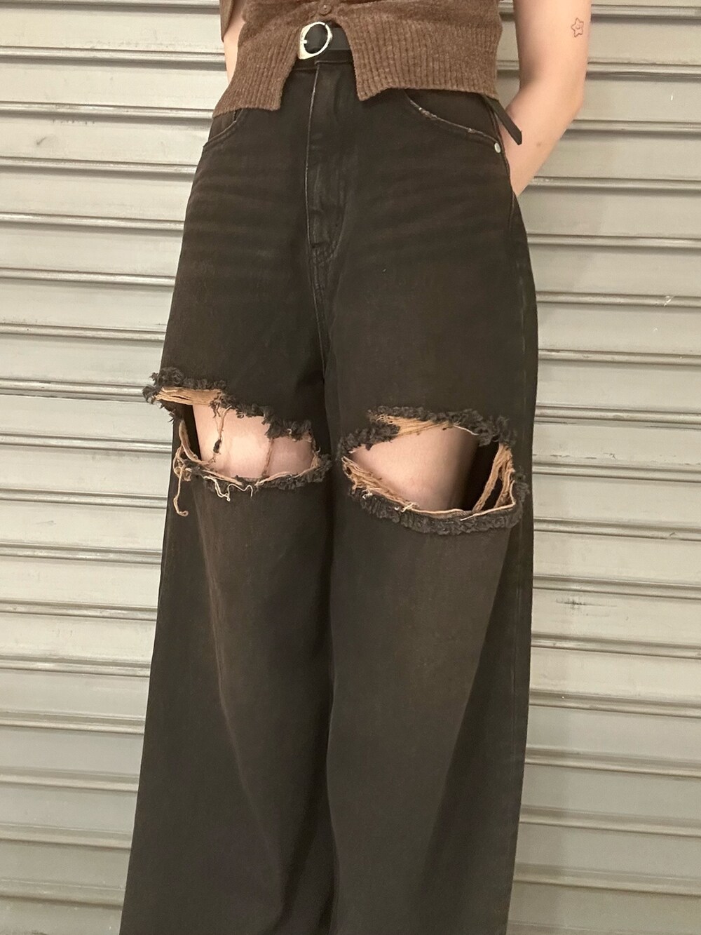 ブラウン系のニット/セーター、ブラック系のデニムパンツ、ブラック系のサンダルを着用したレディースの夏コーディネートの5枚目の写真