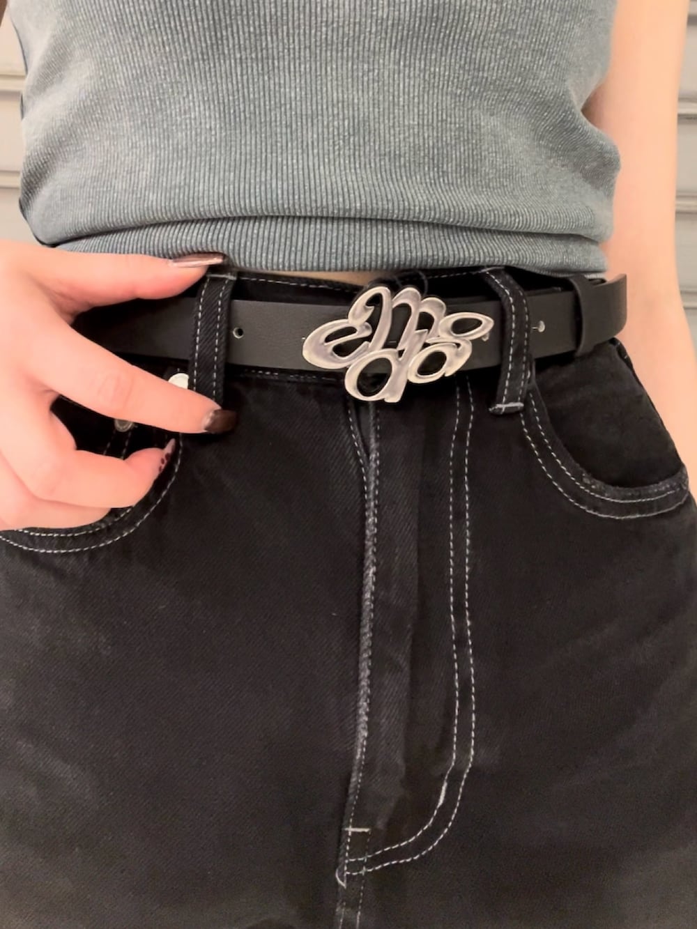 ブルー系のタンクトップ、ブラック系のデニムパンツ、ブラック系のハンドバッグを着用したレディースの夏コーディネートの5枚目の写真