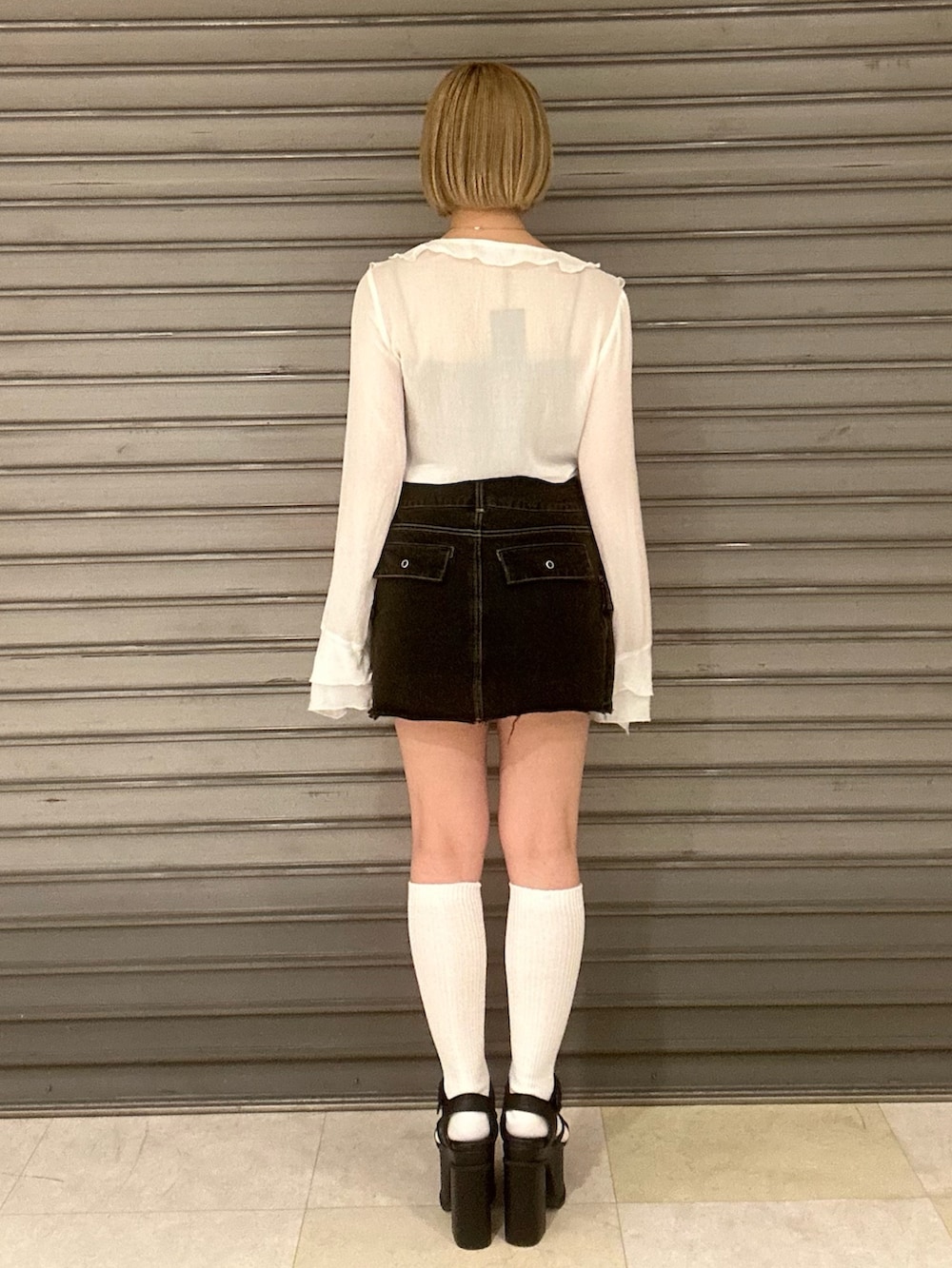 グレー系のTシャツ/カットソー、ホワイト系のシャツ/ブラウス、ブラック系のスカートを着用したレディースの春コーディネートの3枚目の写真