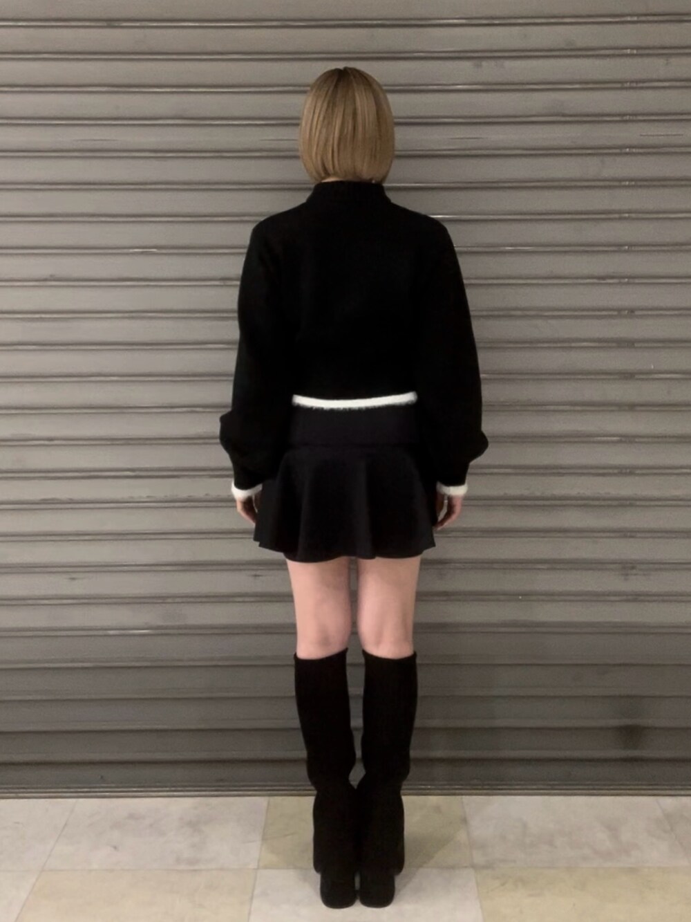 ブラック系のニット/セーター、グレー系のその他アウター、ブラック系のスカートを着用したレディースの冬コーディネートの7枚目の写真